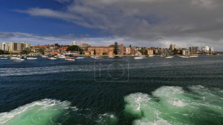 Photo for View of the residential harborside of the North Head peninsula crowded with anchored and moored boats seen from a Manly bound ferry about to start its docking maneuver. Sydney Harbour-NSW-Australia. - Royalty Free Image
