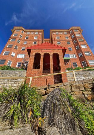 Téléchargez les photos : Red brick-residential unit-block building overlooking the southern end of the beach finished in 1930 at the beginning of the Marine Parade walkway in Manly suburb. Sydney-New South Wales-Australia. - en image libre de droit