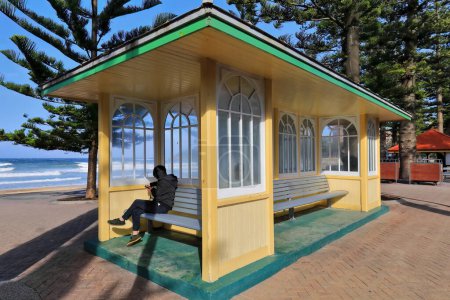 Téléchargez les photos : UNRECOGNIZABLE INCIDENTAL PEOPLE IN THE IMAGE. The Shelter Shed at South Steyne in Manly suburb unveiled in 16 March 1940 is an icon for local and tourist beachgoers placed next to the entrance stairs to the beach. Sydney-New South Wales-Australia - en image libre de droit