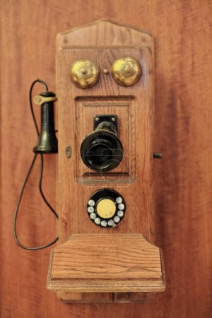 Photo for Antique wall mounted wood telephone-fiddleback cathedral type with rotary dialer, switch hook, OST pony receiver, transmitter with black metal mouthpiece, two ringers, and crank. Sydney-NSW-Australia. - Royalty Free Image