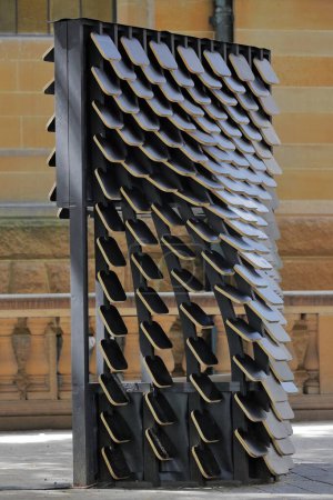 Téléchargez les photos : Pavillon temporel à l'extérieur de la Bibliothèque d'État de Nouvelle-Galles du Sud et à côté de la statue Matthew Flinders avec un cadre en bois noir incurvé revêtu de bardeaux d'aluminium anodisé mat. Sydney-NSW-Australie. - en image libre de droit