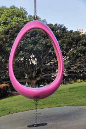 Téléchargez les photos : Balançoire à œufs rose-rouge avec poteau et chaîne droits en acier, allégorie de la maternité et de la fertilité sur l'ancien site de l'Hôpital royal pour femmes, aujourd'hui le parc homonyme. Paddington banlieue-Sydney-NSW-Australie. - en image libre de droit