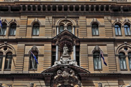 Foto de Fachada norte del edificio histórico catalogado en estilo renacentista italiano victoriano con un grupo de estatuas de mármol blanco de la reina Victoria flanqueadas por figuras alegóricas. Sydney-NSW-Australia. - Imagen libre de derechos