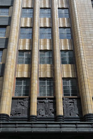 Foto de Fachada de un edificio de estilo Art-Deco de siete plantas del año 1939 que muestra paneles en bajorrelieve sobre la entrada que representa la progresión tecnológica de la industria del agua. Pitt Street-Sydney-NSW-Australia. - Imagen libre de derechos