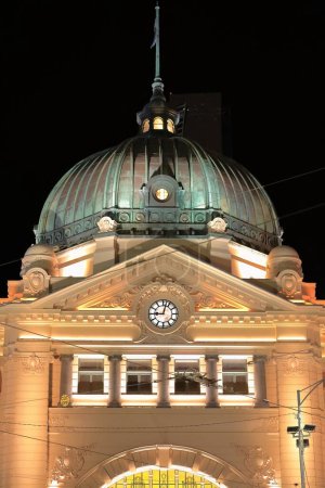 Foto de Prominente cúpula revestida de cobre verde oxidado del edificio de la estación de tren de Flinders Street desde 1909 en estilo eduardiano en la esquina de Flinders y Swanston Streets, y el reloj principal. Melbourne-VIC-Australia. - Imagen libre de derechos