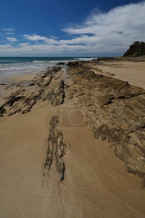 Photo for West-east view at low tide over the Lorne Beach rock formations in Louttit Bay and Point Grey at the southeast going into the wavy sea of the Southern Ocean-Bass Strait. Surf Coast Shire-VIC-Australia - Royalty Free Image