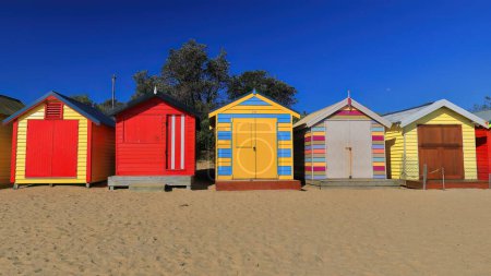 Téléchargez les photos : Plusieurs des 82 boîtes de bain victoriennes colorées le long de Dendy Street Beach, structures en bois face à la baie de Port Phillip vu en fin d'après-midi, Brighton Beach Suburb. Melbourne-VIC-Australie. - en image libre de droit