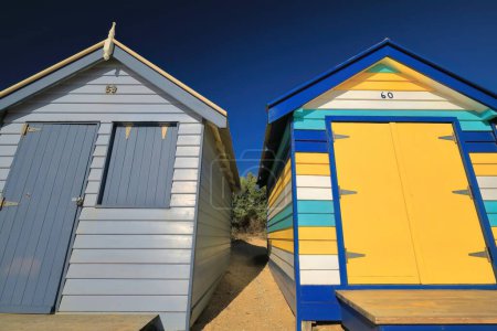 Téléchargez les photos : Deux des 82 boîtes de bain victoriennes colorées le long de Dendy Street Beach, structures en bois orientées à l'ouest de Port Phillip Bay vu en fin d'après-midi, Brighton Beach Suburb. Melbourne-VIC-Australie. - en image libre de droit