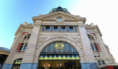 Flinders Street Railway Station building from AD 1909 in Edwardian style at Flinders and Swanston Streets corner in the late evening with its dome, arched entrance, clocks. Melbourne-VIC-Australia.