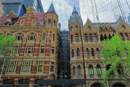 Foto de Melbourne, Australia-22 de octubre de 2018: Los edificios de Rialto y Winfield, Collins Street, datan de 1890-1891, tienen un nivel de detalle similar en altura y anchura, y conforman un notable paisaje urbano victoriano.. - Imagen libre de derechos