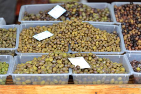 Téléchargez les photos : Olives de table principalement vertes cultivées localement dans les zones environnantes mises en vente dans des boîtes en plastique dans un stand du marché du Pazari i Ri-New Bazaar dans la vieille ville. Tirana-Albanie. - en image libre de droit