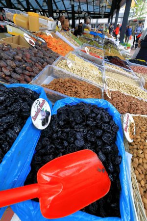 Téléchargez les photos : Stalle vendant un hodgepodge de raisins secs, noix et fruits secs mis en vente dans des casseroles en plastique avec une pagaie de service rouge. Marché dans le Pazari i Ri-New Bazaar de la vieille ville, Tirana-Albanie - en image libre de droit
