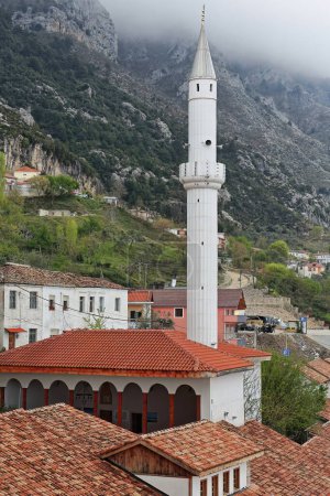 Photo for View of the Murat Bey Camisi-Bazaar or Suburban Mosque -Xhamia e Pazarit, Xhamia e Varoshit- with its white minaret protruding among the buildings along the Pazarit i Vjeter-Old Bazaar. Kruja-Albania. - Royalty Free Image