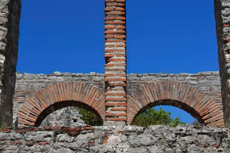 Photo for Brickwork-made round arches on the southern aisle outer wall, great basilica built between the 5th century AD end and the 6th century AD beginning, Butrint archaeological site. Vlore county-Albania. - Royalty Free Image