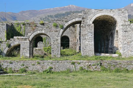 Photo for Remains of stepped arcade of four arches -in crescendo, alternately one half-sized, the next complete- made of stone block masonry on the upper-central courtyard of the fortress. Gjirokaster-Albania. - Royalty Free Image