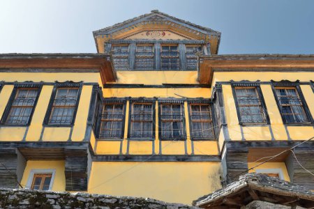 Téléchargez les photos : Maison de style ottoman façade jaune de la fin du XVIIIe siècle reconstruite en 1902, avec les deux ailes habituelles et la disposition centrale du noyau, surmontée d'un grenier, dans la vieille ville-quartier de Palorto. Gjirokaster-Albanie - en image libre de droit