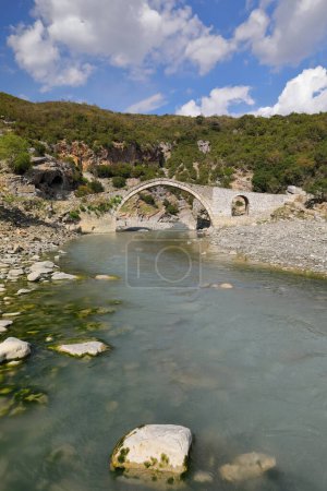 Photo for The mid-XVIII century built, Ottoman Katiu Bridge -Ura e Kadiut, Judge's Bridge- spanning 15'50m over the Langarica river marks the beginning of the river canyon. Benje village-Permet town-Albania. - Royalty Free Image