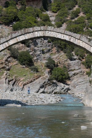 Foto de A mediados del siglo XVIII, el puente otomano Katiu-Ura e Kadiut, puente del juez, que se extiende 15 '50m sobre el río Langarica, marca el comienzo del cañón del río. Benje pueblo-Permet ciudad-Albania. - Imagen libre de derechos