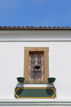 Foto de Detalle de ventana de madera barrada en la pared blanca de un edificio otomano de dos pisos reformado en 2016, en Rrugica Petraq Nasi-Rrugica Stavri Gjerazi, zona Old Bazaar-Pazari i Vjeter-. Korce-Albania. - Imagen libre de derechos