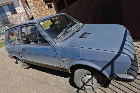 Téléchargez les photos : Ohrid, Macédoine du Nord-19 avril 2019 : Ancienne Zastava Yugo 45Une voiture de 1986 fabriquée dans la Yougoslavie éteinte sur la base d'une voiture italienne Fiat 128, est toujours en service en 2019 dans le village d'Elsani. - en image libre de droit
