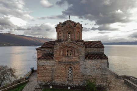Photo for Westward view from Plaosnik archaeological site over the Saint John the Theologian at Kaneo -Sveti Jovan Kaneo- church to the lake and the Shebenik mountains in the background. Ohrid-North Macedonia. - Royalty Free Image