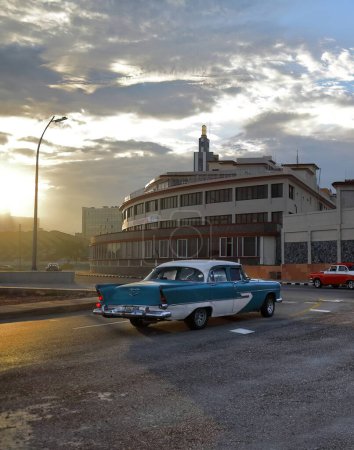 Foto de La Habana, Cuba-07 de octubre de 2019: Old blue and white painted American classic car-almendron, yank tank- Plymouth Savoy 4 door Sedan from 1956 drives along El Malecon promenade in El Vedado neighborhood. - Imagen libre de derechos