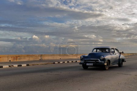 Foto de La Habana, Cuba-07 de octubre de 2019: Old blue-white American classic car-almendron, yank tank- Chevrolet Deluxe 4 door Sedan from 1951 drives along El Malecon promenade in El Vedado neighborhood. - Imagen libre de derechos