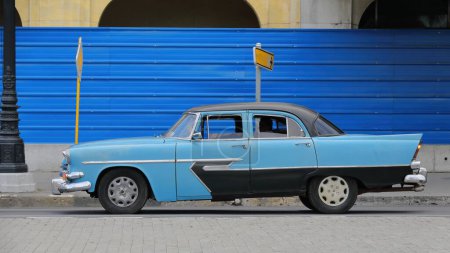 Foto de La Habana, Cuba-07 de octubre de 2019: Vehículo clásico americano de color azul claro y oscuro, tanque de yanqui Plymouth Cranbrook Belvedere 4 puertas Sedán de 1956 se detiene en un semáforo rojo, Paseo del Prado. - Imagen libre de derechos