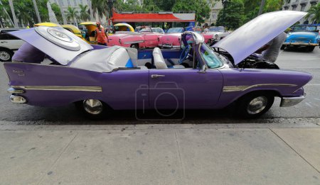 Foto de Havana, Cuba-October 07, 2019: Purplish blue old American classic car-almendron, yank tank- Dodge Kingsway Custom Convertible 1959 sufre algunos problemas, motor en reparación, Paseo del Prado. - Imagen libre de derechos