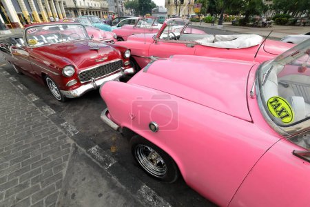 Foto de La Habana, Cuba-07 de octubre de 2019: Mess of American classic convertible cars pink Chevrolet Styleline DeLuxe 52-Bel Air 1953 and Mercury Monterey 1953, red Chevrolet Bel Air 1955 park on Paseo del Prado. - Imagen libre de derechos