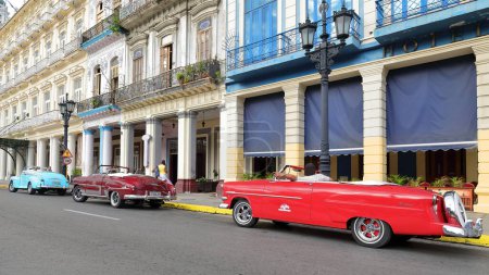 Foto de La Habana, Cuba-7 de octubre de 2019: Tres coches descapotables americanos clásicos azul-granate Ford Super DeLuxe 1947-48, Chevrolet Styleline DeLuxe 1952, Ford Crestline Victoria 1953- park on Paseo del Prado - Imagen libre de derechos