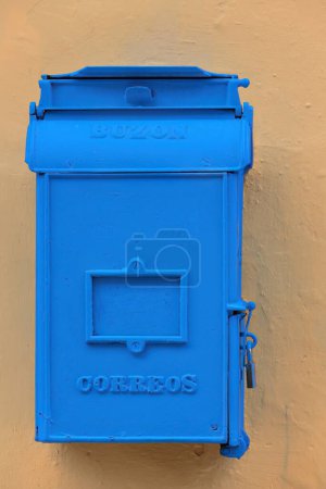 Téléchargez les photos : Vintage boîte postale bleue buzon de correos, comme indiqué sur sa surface- de la poste Correos- pour le courrier sortant, cadenas fermé et attaché à un mur de bâtiment ocre-orange. Vieille Havane-Cuba. - en image libre de droit