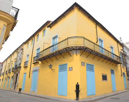 Fachada, casa colonial de estilo barroco del año 1648 reconstruida en 1780 y reformada en la década de 1980, esquina de las calles Obrapia y Mercaderes NW, paredes pintadas de amarillo e intrincado pórtico. Habana Vieja-Cuba.