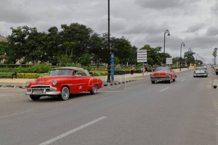 Foto de La Habana, Cuba-7 de octubre de 2019: Coches clásicos americanos Chevrolet Styleline Deluxe Convertible '52, Buick Century Convertible' 58, Chevrolet Bel Air Sedan '56 drive along Avenida del Puerto-Port Avenue. - Imagen libre de derechos