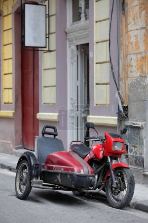 Foto de La Habana, Cuba-7 de octubre de 2019: Antigua, clásica, pintada de rojo, motocicleta checa de 1991-Jawa 350 cc, Tipo 640- con sidecar adjunto-Velorex Tipo 560- estaciones junto a la acera en la calle Virtudes. - Imagen libre de derechos