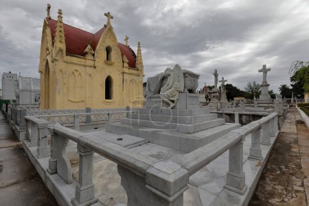 White marble sculptures on pedestals upon graves and Neo-Gothic style pantheon, Cementerio de Colon Cemetery containing elaborately sculpted memorials estimated to be 500 plus mausoleums. Havana-Cuba.