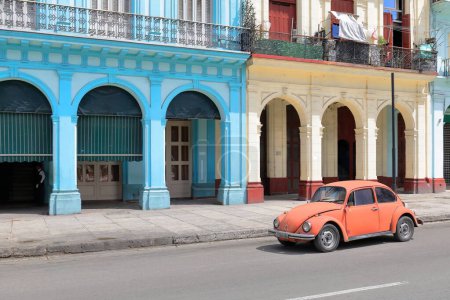 Foto de La Habana, Cuba-8 de octubre de 2019: El viejo automóvil clásico de la economía europea naranja de la puerta 2 de los años 70 Volkswagen Tipo 1, el llamado Escarabajo, conduce por el paseo marítimo del Prado hacia el extremo sur, lado este. - Imagen libre de derechos