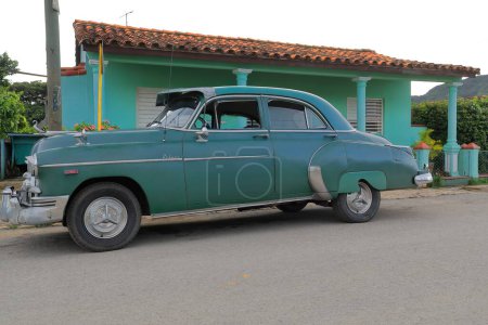 Foto de Vinales, Cuba-9 de octubre de 2019: Green American classic car-almendron- Chevrolet Styleline Deluxe Sedán de 4 puertas 1949 con ligeras modificaciones estacionadas en la calle Adela Azcuy al comienzo del atardecer. - Imagen libre de derechos