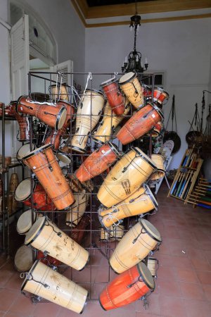 Photo for Cienfuegos, Cuba-October 11, 2019: Set of Cuban percussion instruments -congas or tumbadoras, makutas, bongos, batas, timbales- displayed for sale in a souvenir shop of the Plaza Jose Marti Square. - Royalty Free Image