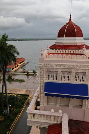 Cienfuegos, Cuba-October 11, 2019: Palacio de Valle Palace, eastward view over the rooftop pavilion and northeast turret to the east bay under stormy sky at late afternoon after a heavy tropical rain.