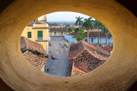 Photo for Trinidad, Cuba-October 12, 2019: Early sunset, SE-wards view from the San Francisco Church belfry of Cristo Street, Plaza Mayor Square, Brunet Palace, Sanchez Iznaga Estate, framed by an oval window. - Royalty Free Image