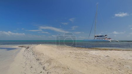 El catamarán de crucero turístico navegando desde la isla principal a Cayo Iguana o Macho de Afuera Key y atras atracado en el muelle de madera en el anclaje de la pequeña pieza de tierra arenosa. Trinidad-Cuba.