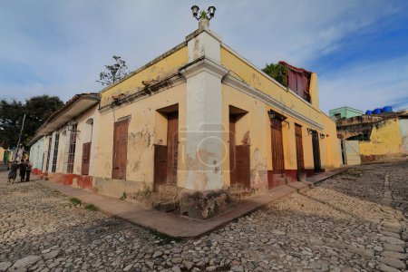 Photo for Trinidad, Cuba-October 13, 2019: Dilapidated, chipped facade of colonial style, one-storey building at the Calle Alameda and Calle Cristo Streets northeast corner painted in peach-yellow-orange colors - Royalty Free Image