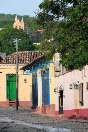 Trinidad, Cuba-October 13, 2019: Northeastward view along Calle Alameda Street to houses on Calle Amargura Street, the Ermita Nuestra Senora de la Candelaria de la Popa Hermitage ruins in background.