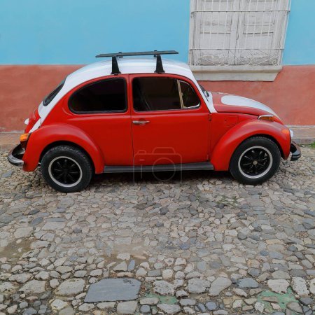 Photo for Old 2-door, red and white European economy classic car -Volkswagen Type 1, so-called Beetle- on Calle Amargura Street number 70. Trinidad-Cuba-270 - Royalty Free Image