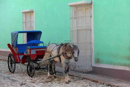 Trinidad, Cuba-October 13, 2019: Colonial horse carriage for sightseeing tours around the cobbled city center, waiting for customers while stationed at 59 Calle Cristo Street, Plaza Mayor Square area.