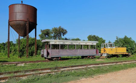 Photo for Trinidad, Cuba-October 14, 2019: Wood cars of the Valle de los Ingenios-Sugar Mills Valley historic train at the station next to a water tower before starting its daily round trip to the plantations. - Royalty Free Image