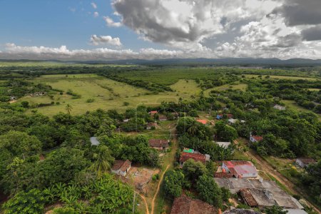 Téléchargez les photos : Bird's eye view from the last floor of the Manaca Iznaga tower over the estate's picturesque countryside made up of farmlands, forests, patchwork fields and the far Escambray Mountains. Trinidad-Cuba. - en image libre de droit