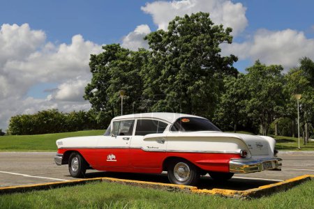 Foto de Santa Clara, Cuba-14 de octubre de 2019: Viejo blanco con coche clásico americano rojo Chevrolet Delray Sedán de 4 puertas de 1958- estacionado junto a la Plaza Ernesto Che Guevara que contiene su mausoleo. - Imagen libre de derechos