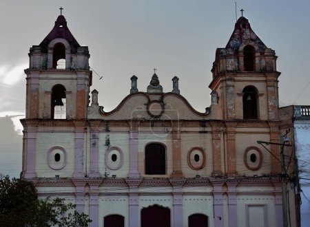 Camaguey, Cuba-October 15, 2019: Southeast facing Baroque facade of the AD 1825 built, two-towered Iglesia Nuestra Senora del Carmen-Our Lady of Carmen Church on Plaza del Carmen Square, at twilight.